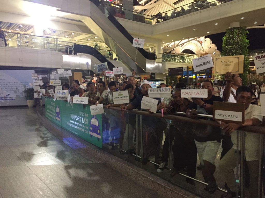 sortie de l'aéroport de Bali avec des dizaines de chauffeurs portant tous une pancarte avec la direction d'Ubud